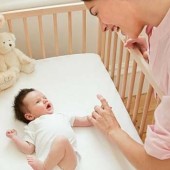 mother_with_baby_in_crib_is098un8s